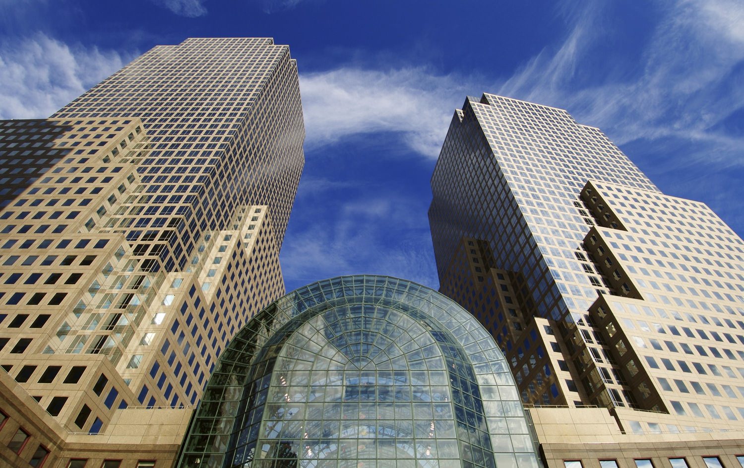 Upward view of a skyscraper with a glass atrium.