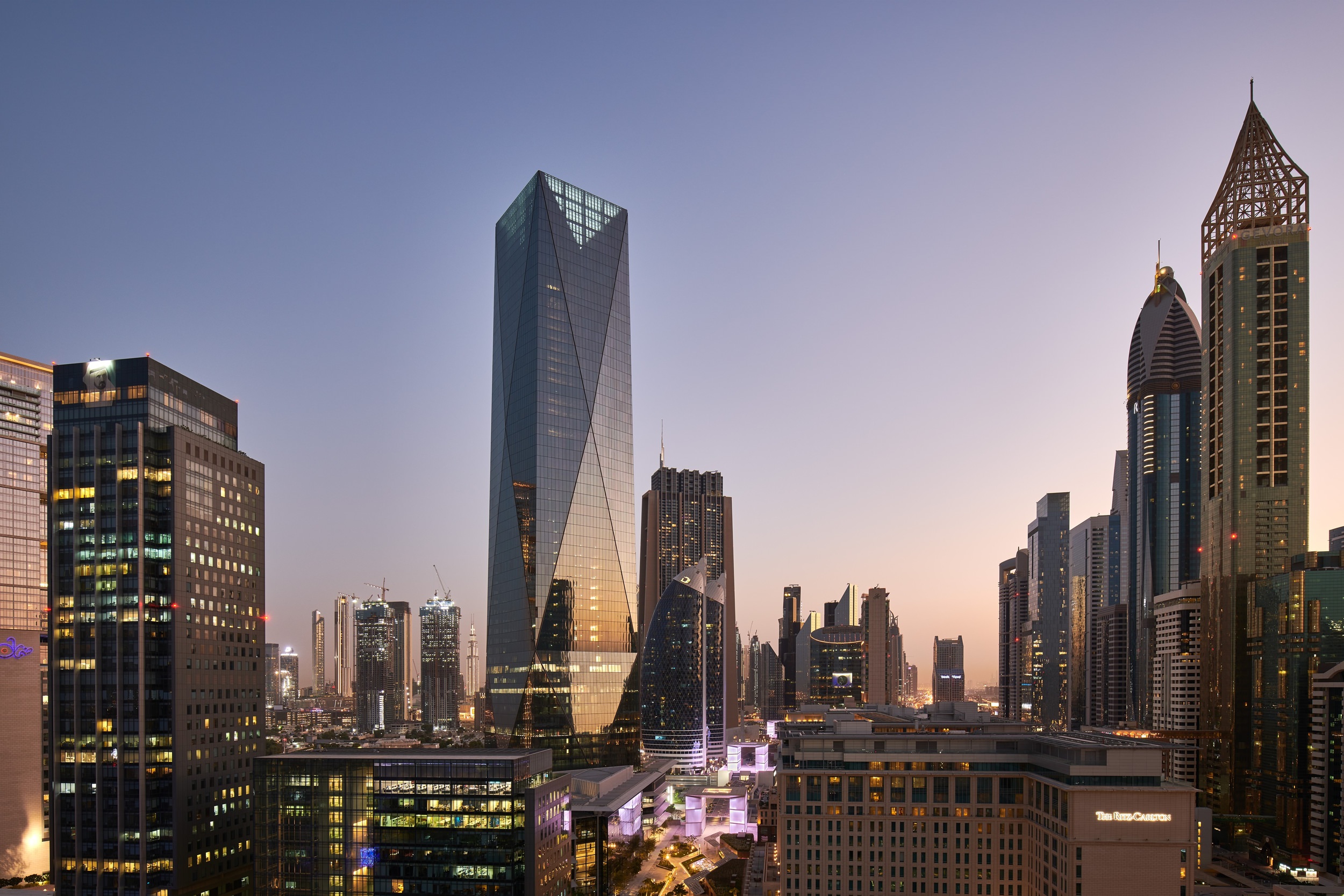 A lot of buildings that are in the downtown area of a city and there are glass panels on them.
