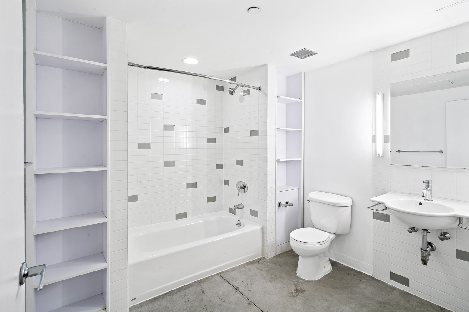A bathroom with white tiles on the walls and a toilet on top of a marbled floor.