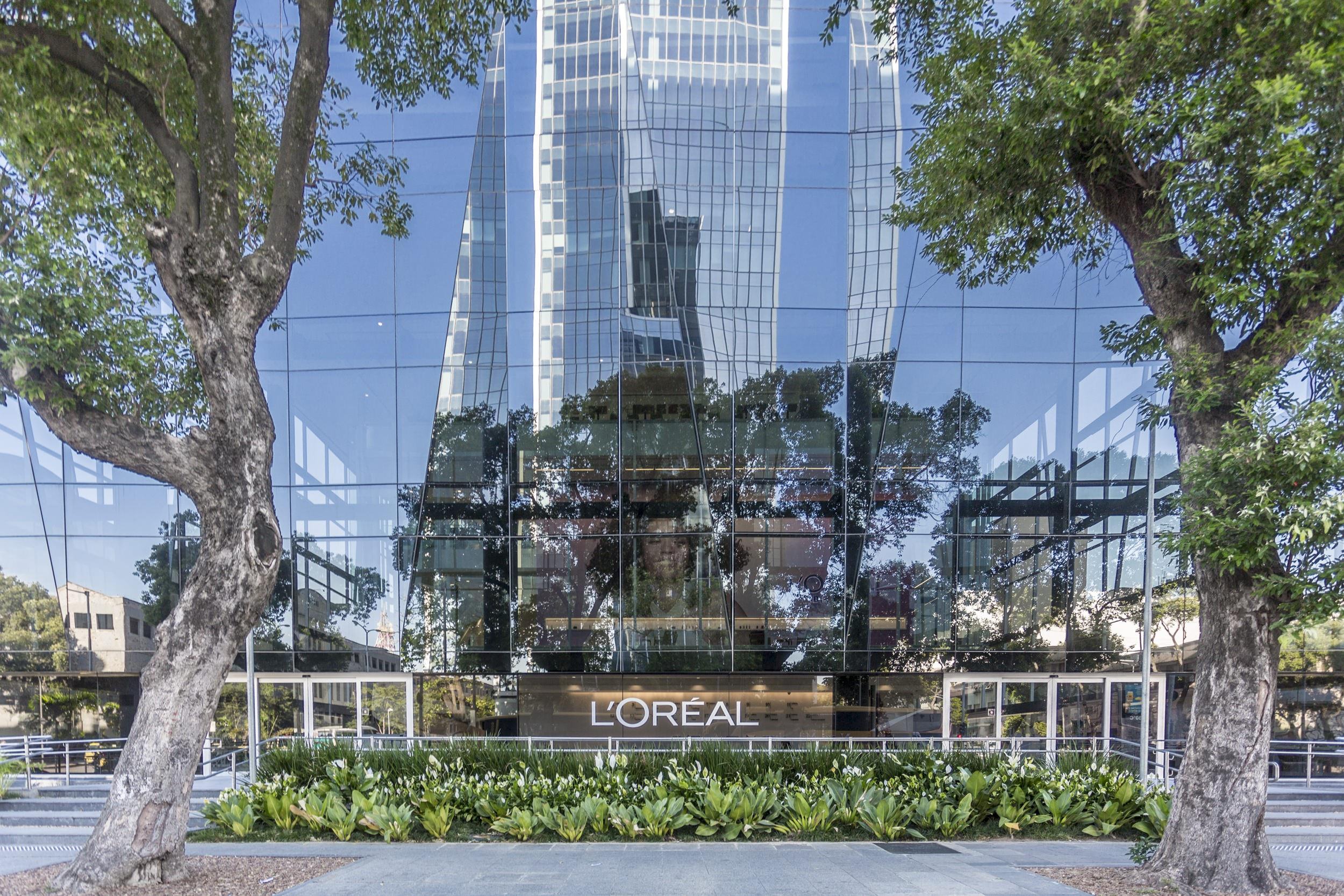 A photo taken from the sidewalk that is in front of a building that has a L'oreal sign on the front
