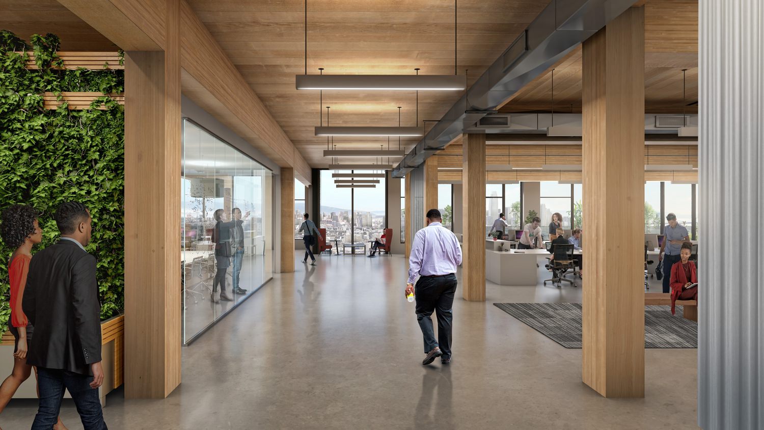A man walks through an office building where people sit and work.