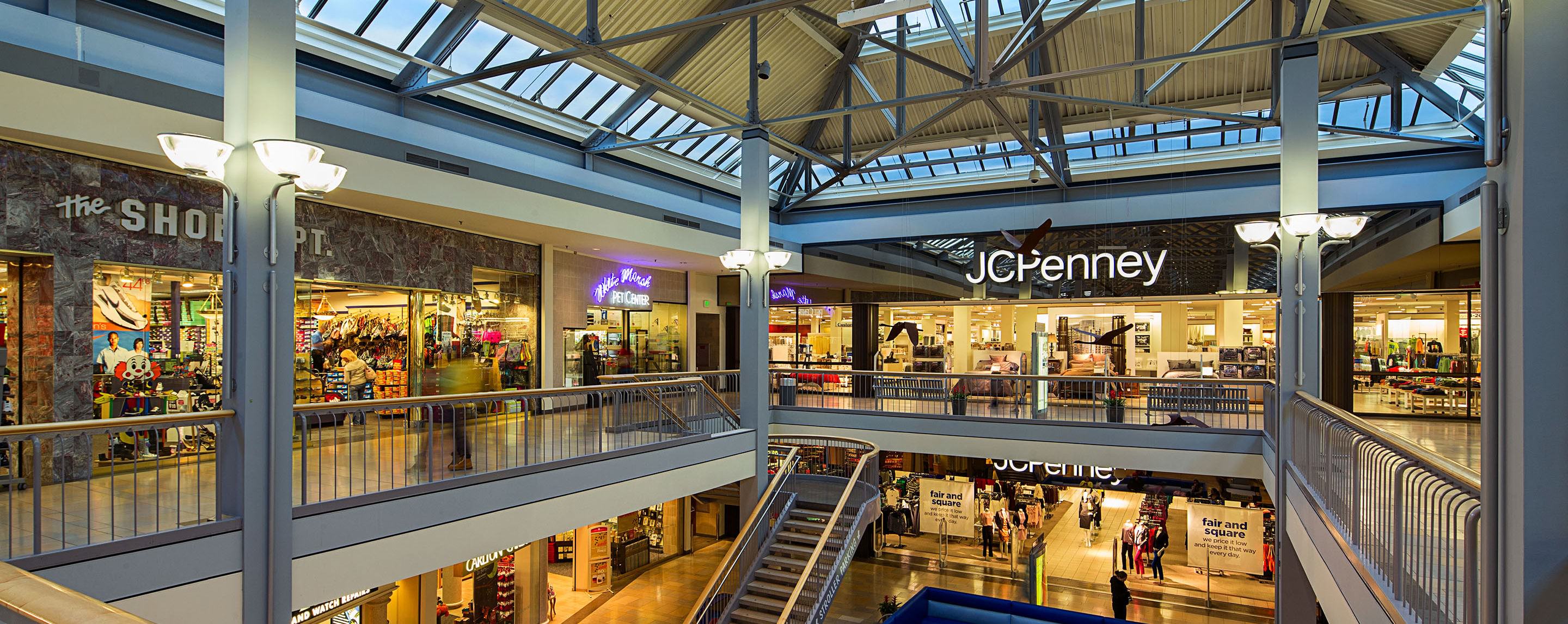 An indoor shot of a several story mall. The storefront for JC Penney can be seen on the far end.