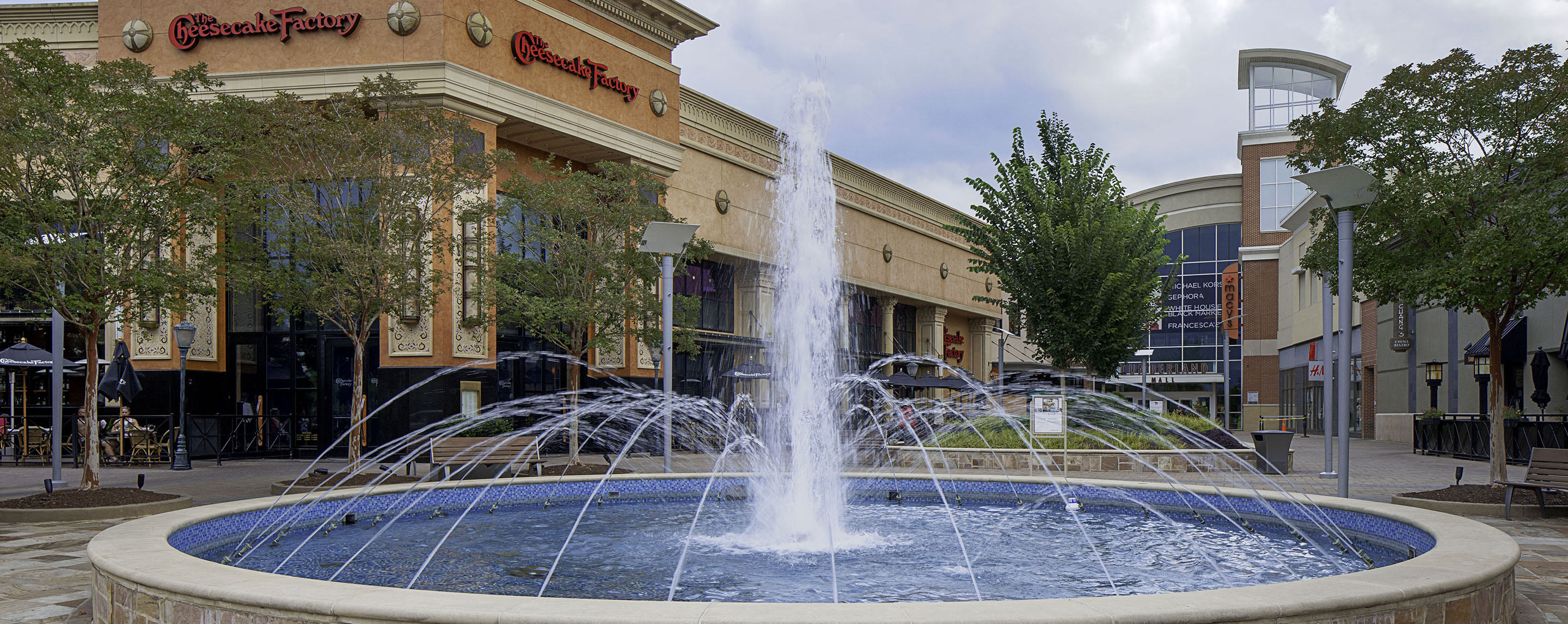 A large fountain outside the Cumberland Mall. Behind it are several storefronts.