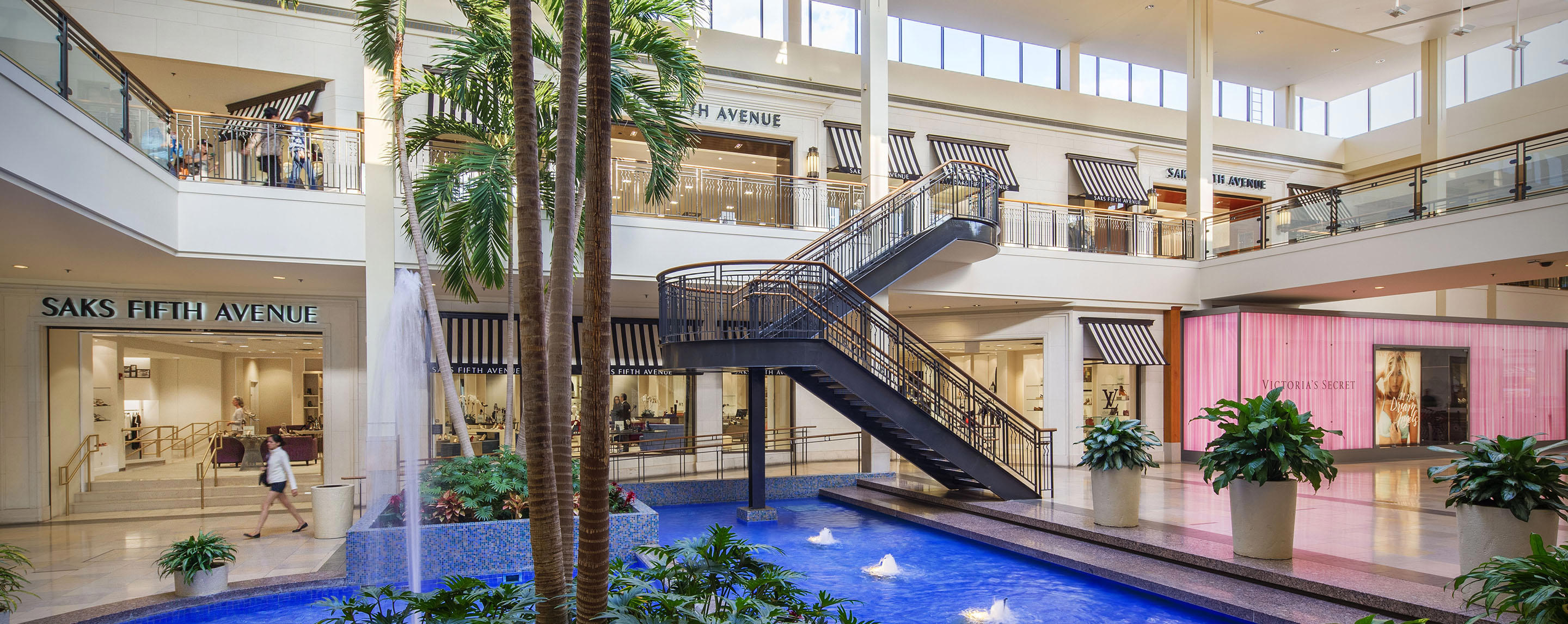 Interior of a mall with two levels connected by a staircase.