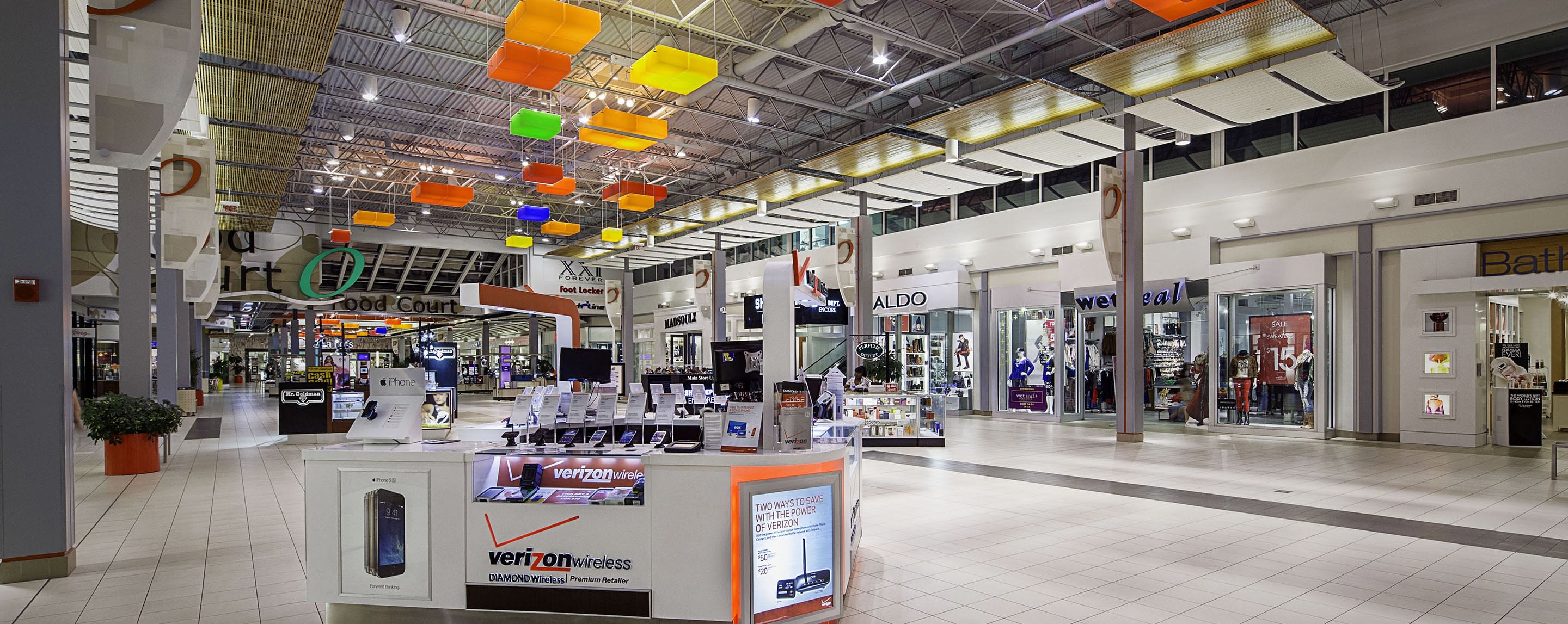 An interior of a mall with a variety of stores, including ALDO, Verizon, Foot Locker, and Mr. Goldman.