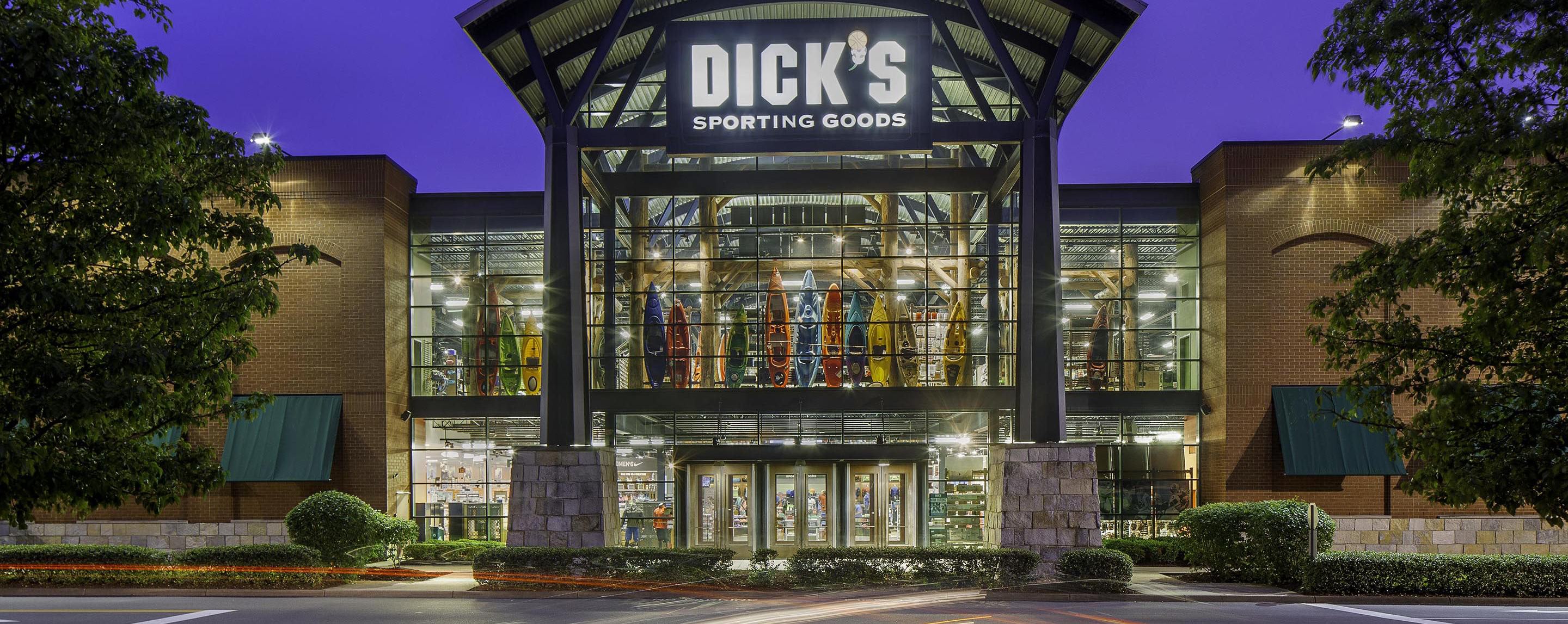 An outside shot of the storefront for Dick's Sporting Goods. The storefront is well lit and several stories tall.