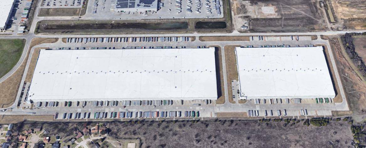 Aerial view of two warehouses with parking for trucks.
