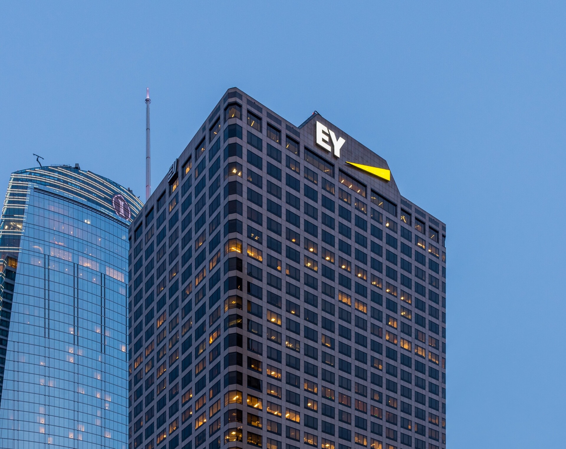 View looking up at a skyscraper that says EY.